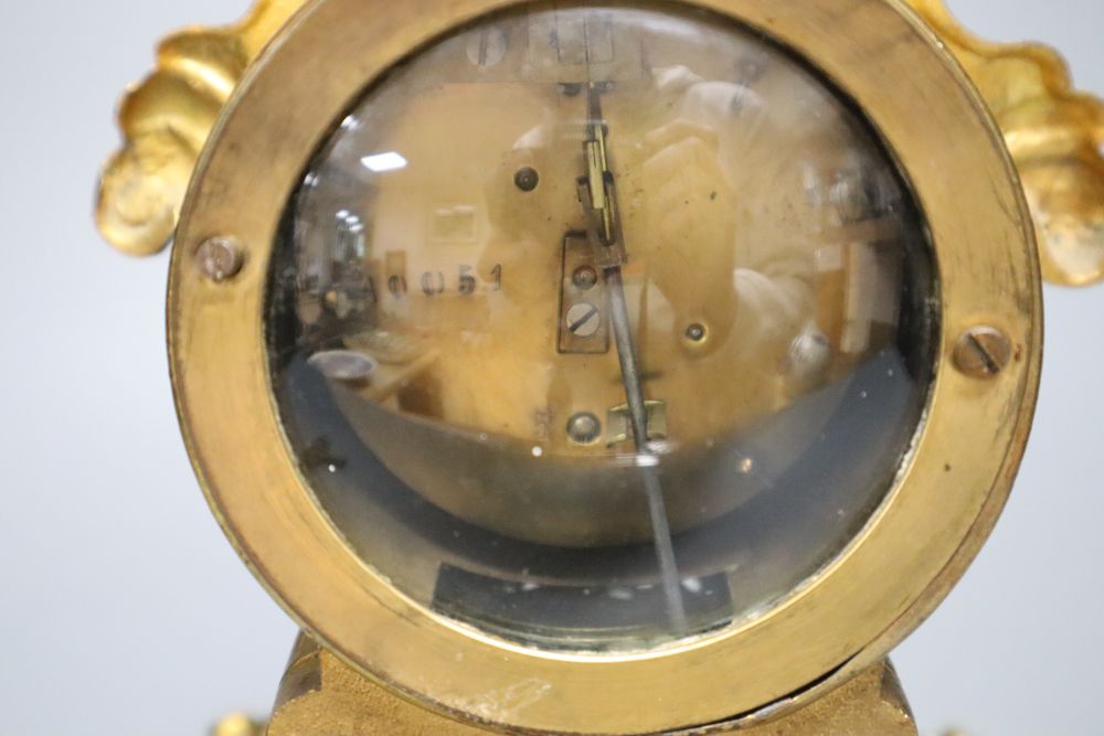 A 19th century French gilt metal mantel timepiece, with ceramic dial, pendulum and key, 31cm